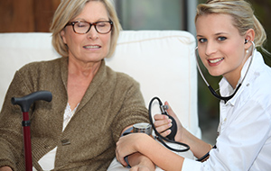 A doctor taking her patient blood pressure.
