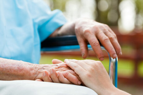 Alzheimer's caregiver in Boca Raton holding hands with an elderly woman